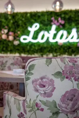 a chair with a floral pattern sitting at a table at Garni Hotel Lotos in Niš