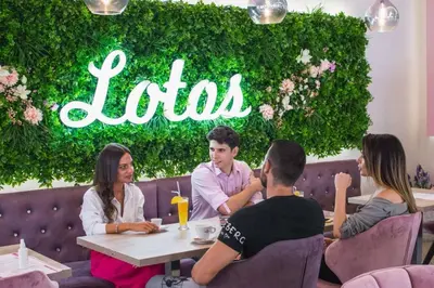 a group of people sitting at a table in a restaurant at Garni Hotel Lotos in Niš