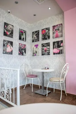 a table and chairs in a room with pink walls at Garni Hotel Lotos in Niš