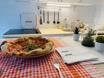 a pizza on a plate on a table in a kitchen at Sokobanja Apartman Aleksa in Soko Banja