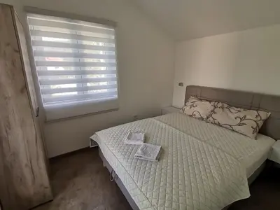 a bedroom with a bed with a window and two towels at Podinario in Soko Banja
