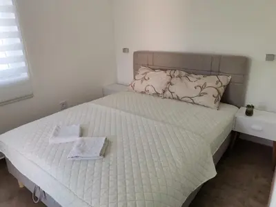a bedroom with a bed with two towels on it at Podinario in Soko Banja