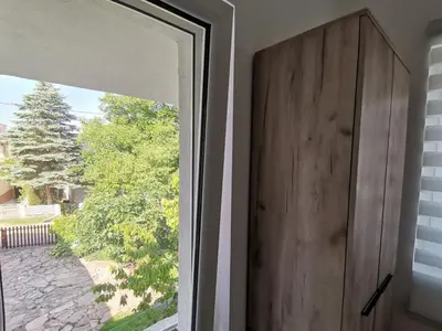 a sliding glass door in a room with a window at Podinario in Soko Banja