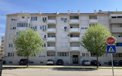 an apartment building with a stop sign in front of it at Apartman Senjak in Pirot