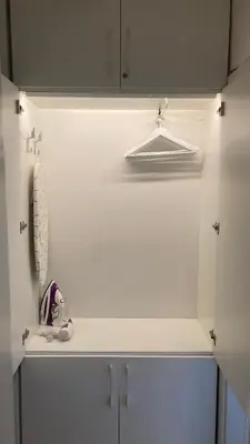 a kitchen with white cabinets and a hanger at Apartman Senjak in Pirot