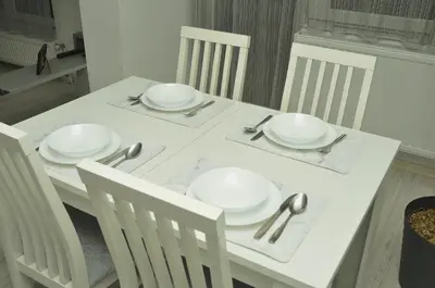 a white table with white plates and silverware on it at 