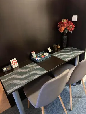 a table with two chairs and a vase with flowers at 4 Rooms Apartments in Niš