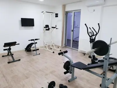 a gym with several treadmills and exercise bikes at SAPA Studios & Apartments in Niš