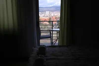 a bedroom with a window with a view of a city at SAPA Studios & Apartments in Niš