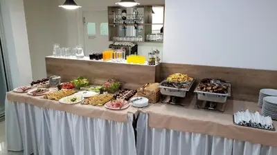 a table with a buffet of food on it at SAPA Studios & Apartments in Niš