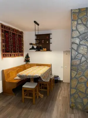 a living room with a table and a couch at Vila NADJA in Kopaonik