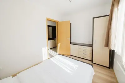 a bedroom with a white bed and a mirror at Apartment Unna in Kopaonik