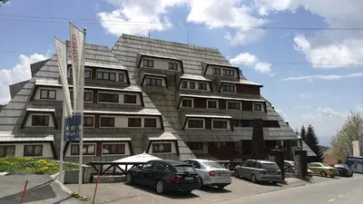 a building with cars parked in front of it at Apartment Unna in Kopaonik