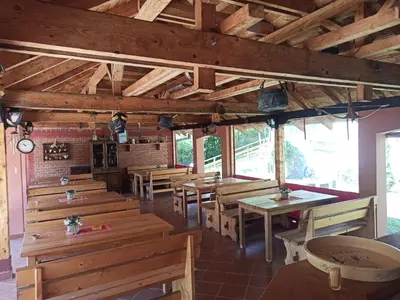 a restaurant with wooden tables and benches in a room at Kod Dace in Banja Topilo