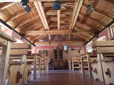 a large room with wooden ceilings and tables and chairs at Kod Dace in Banja Topilo