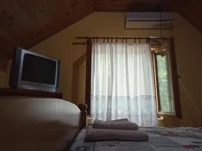 a bedroom with a bed and a tv and a window at Kod Dace in Banja Topilo