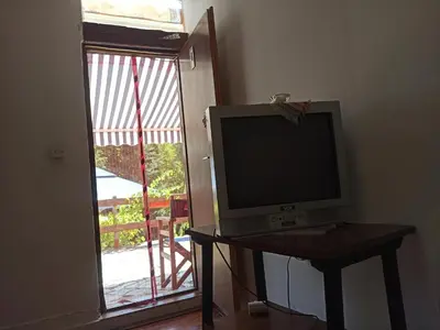 a television sitting on a table in front of a door at Kod Dace in Banja Topilo