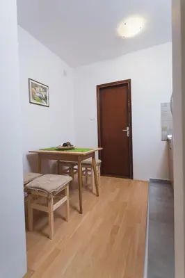 a room with a table and chairs and a door at Guest House SokoDream in Soko Banja