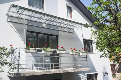 a balcony with geraniums on a house at Guest House SokoDream in Soko Banja