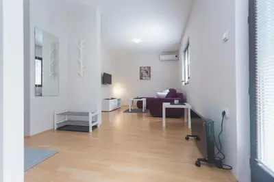 a living room with white walls and a wooden floor at Guest House SokoDream in Soko Banja
