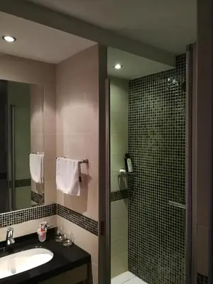 a bathroom with a sink and a shower with a mirror at Apartments MARAS - Angella Konaci in Kopaonik