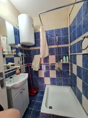 a blue tiled bathroom with a tub and a sink at Apartman 