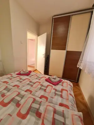 a bedroom with a bed with two clothes on it at Apartman 