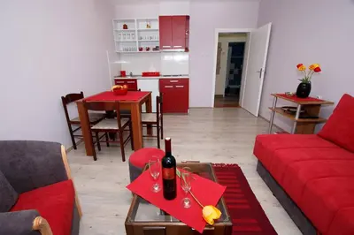 a living room with a red couch and a table at Apartman 