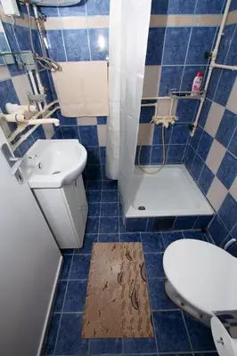 a blue tiled bathroom with a toilet and a sink at Apartman 