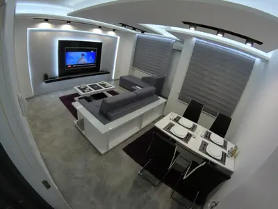a living room with a couch and a television at Grey apartment in Niš