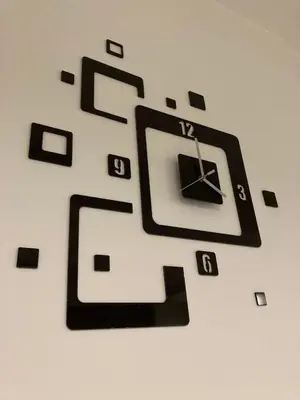 a black clock hanging on a wall at Grey apartment in Niš