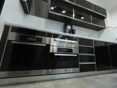 a kitchen with black and stainless steel appliances at Grey apartment in Niš