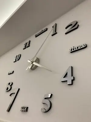 a clock on a wall with numbers on it at Grey apartment in Niš