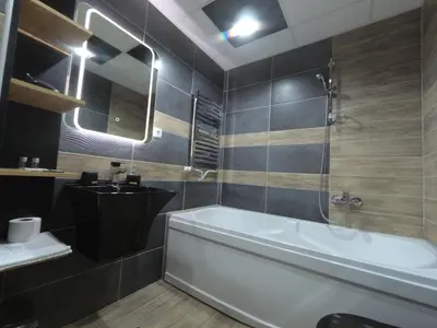 a bathroom with a tub and a sink at Grey apartment in Niš