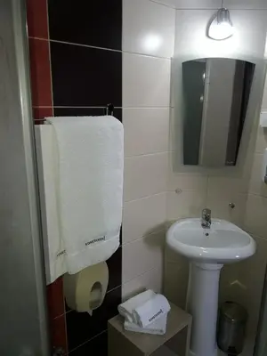 a bathroom with a sink and a white towel at Prenoćište Konstantin 2008 in Niš