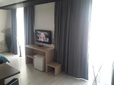 a living room with a tv on a table in a room at Prenoćište Konstantin 2008 in Niš