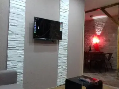 a flat screen tv on a wall in a living room at Apartmani Java in Soko Banja