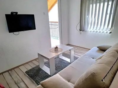 a living room with a white couch and a table at Apartmani Java in Soko Banja