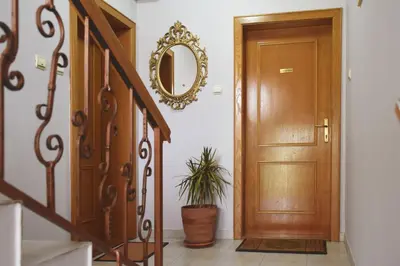 a hallway with a wooden door and a potted plant at Apartmani Boss in Vrnjačka Banja