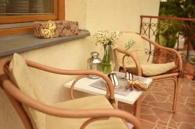 a table and chairs with a vase of flowers on a balcony at Apartmani Boss in Vrnjačka Banja