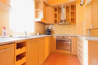 a kitchen with yellow cabinets and a sink at Apartment Sofija in Niš