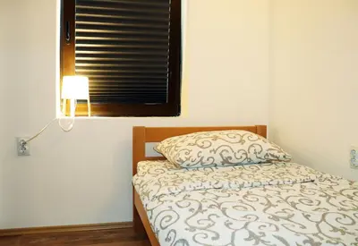 a bedroom with a bed with a pillow and a window at Zeleno srce in Soko Banja