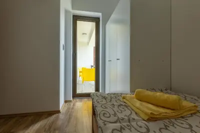 a bedroom with a bed and a yellow chair at Zeleno srce in Soko Banja