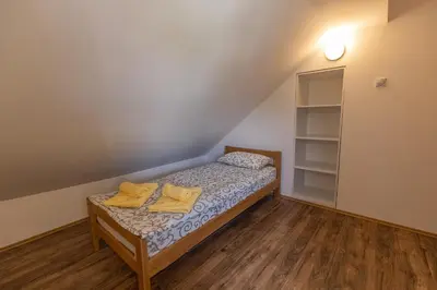 a small bedroom with a bed with yellow towels on it at Zeleno srce in Soko Banja