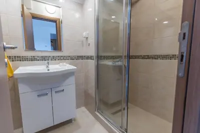 a bathroom with a shower and a sink and a mirror at Zeleno srce in Soko Banja