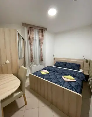 a bedroom with a bed with two yellow pillows on it at Holiday Wing Apartment 2 in Jagodina