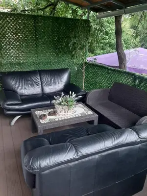 a patio with black leather couches and a table at Apartment Mia in Vrnjačka Banja