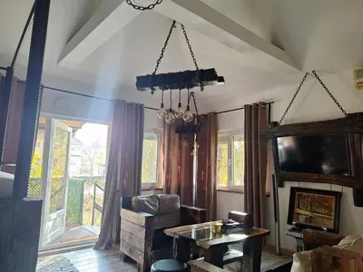 a living room with a chandelier and a table at Apartment Mia in Vrnjačka Banja