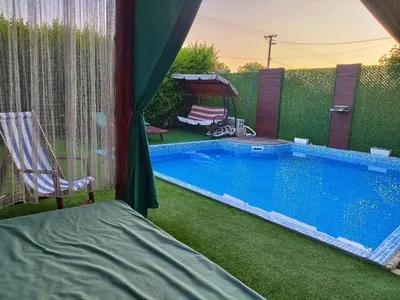 a swimming pool in a yard with a chair next to it at Villa Saturea in Boljevac