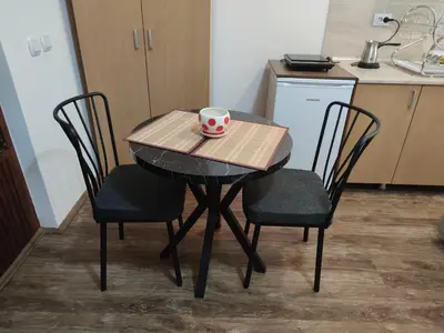 a small table with two chairs and a cup on it at Studio Elizabeta in Soko Banja